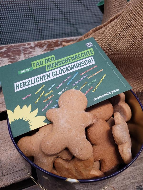 Tag der Menschenrechte Plätzchen in Menschenform in einer Schale mit der Postkarte zum Tag der Menschenrechte