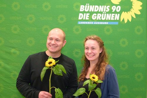 Landratskandidat Felix Senner und Stadträtin Julia Mai aus Stadtbergen posieren mit Sonnenblume in der Hand